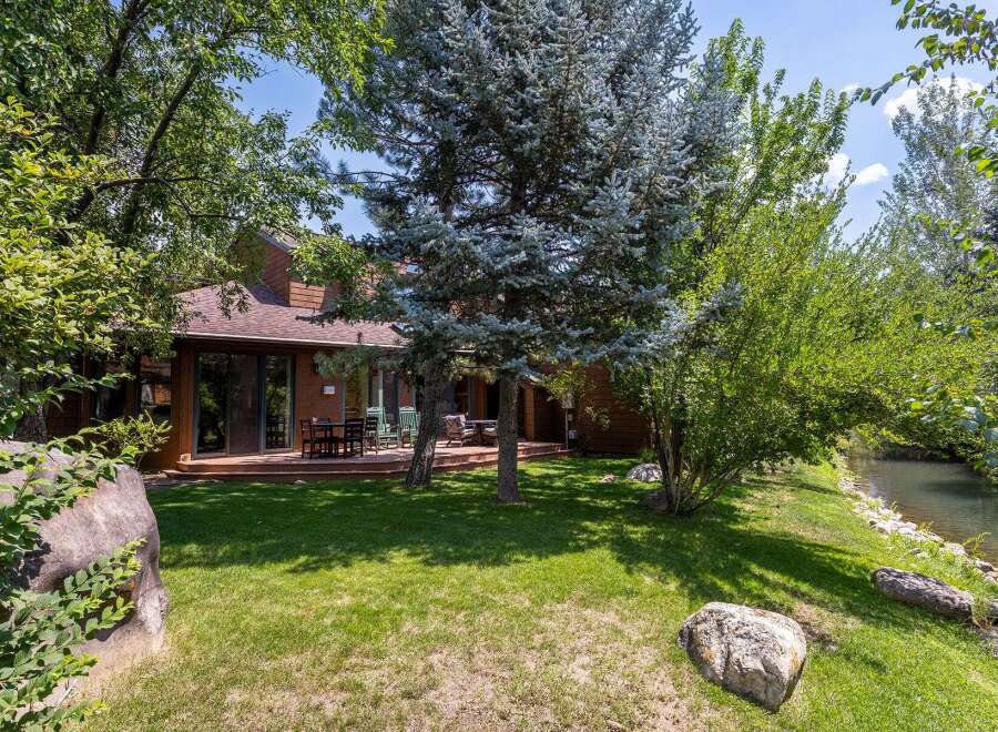 Enjoy serene living with this charming home featuring a spacious wooden deck perfect for outdoor entertaining.