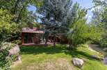 Enjoy serene living with this charming home featuring a spacious wooden deck perfect for outdoor entertaining.