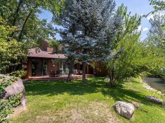Enjoy serene living with this charming home featuring a spacious wooden deck perfect for outdoor entertaining.