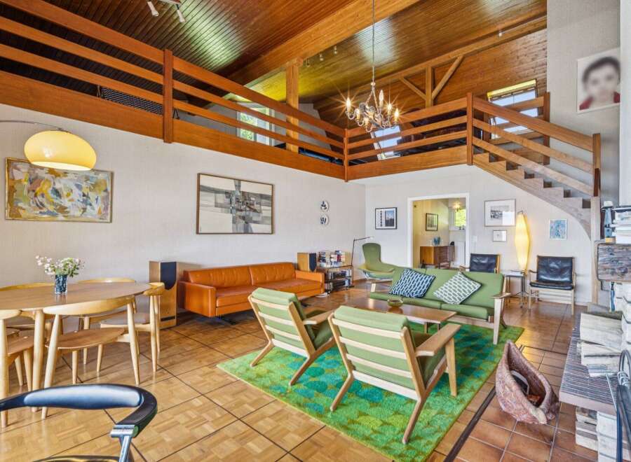 Experience mid-century modern living in this stunning home featuring a dramatic vaulted wood-beamed ceiling and an open loft space.