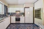 This charming kitchen features a unique blue and brown tiled backsplash and matching floor, creating a retro yet stylish aesthetic.