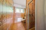 This bathroom features warm, earthy tones with decorative floral tiles and a complementary tiled floor.