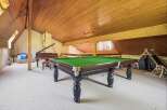 Discover a unique recreational space featuring a classic billiard table and a grand piano, perfect for entertainment and leisure.