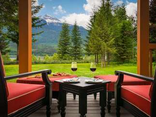 Experience breathtaking mountain views from this stunning property's covered porch, perfect for enjoying a glass of wine.