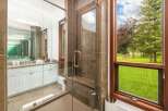 Experience luxury in this stunning bathroom featuring a spacious glass-enclosed shower with a built-in bench and elegant tilework.