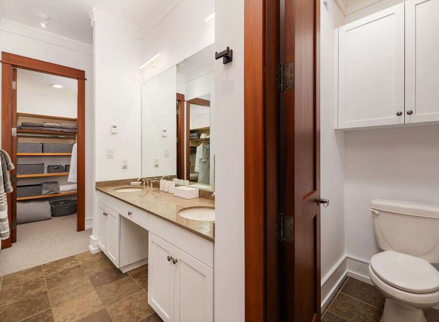This spacious bathroom features a double vanity with ample counter space and storage, perfect for any household.