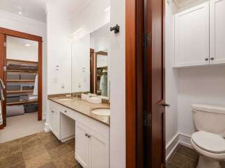 This spacious bathroom features a double vanity with ample counter space and storage, perfect for any household.