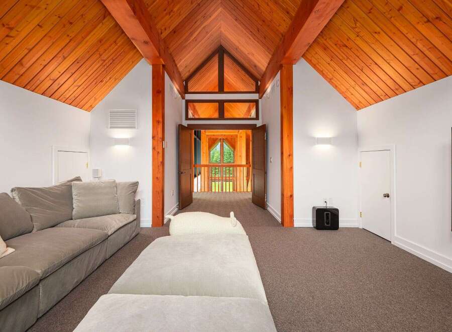 Experience breathtaking views from this stunning property, featuring a vaulted wood-paneled ceiling with exposed beams that create a warm and inviting atmosphere.
