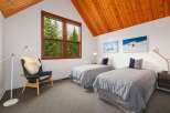 This charming bedroom features two twin beds with cozy grey bedding, perfect for guests or family.