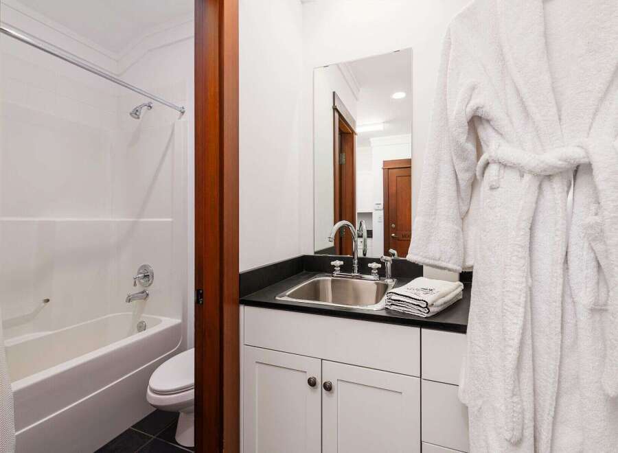 This inviting bathroom features a pristine white bathtub and shower combination, perfect for relaxing soaks or quick rinses.