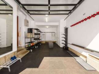 This spacious garage offers ample storage solutions, including multi-tiered shelving units and wall-mounted racks perfect for skis and sports equipment.