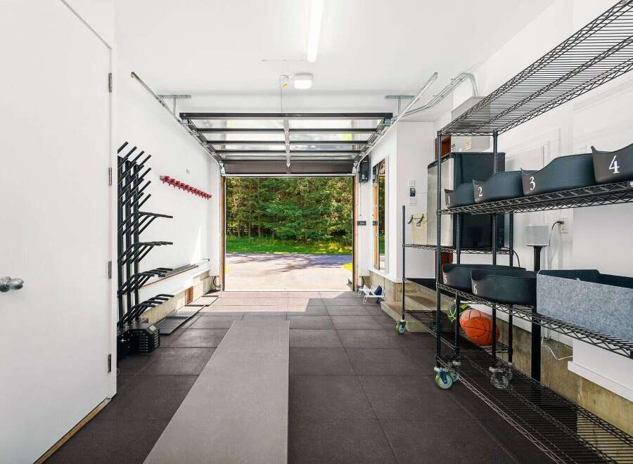 This spacious garage offers a dedicated workout space with ample storage solutions.