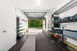 This spacious garage offers a dedicated workout space with ample storage solutions.
