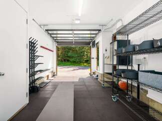 This spacious garage offers a dedicated workout space with ample storage solutions.