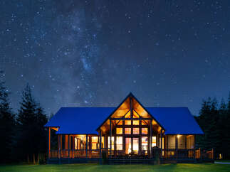 Experience the magic of stargazing from this stunning modern cabin, nestled amongst tall pine trees.