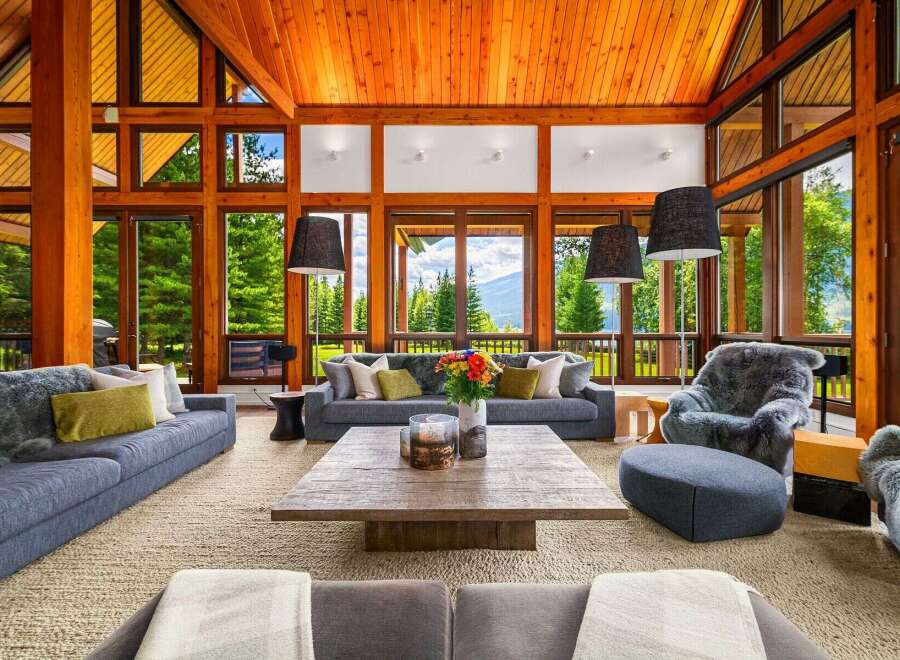Experience luxury mountain living in this stunning great room, featuring a soaring wood-paneled vaulted ceiling and expansive windows that frame breathtaking panoramic views.
