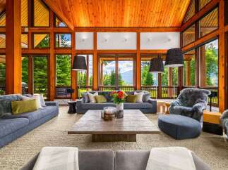 Experience luxury mountain living in this stunning great room, featuring a soaring wood-paneled vaulted ceiling and expansive windows that frame breathtaking panoramic views.