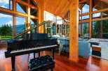 Experience luxury living in this stunning mountain retreat, featuring a grand piano and expansive windows that showcase breathtaking panoramic views.