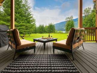 Enjoy breathtaking mountain and lake views from this covered porch, perfect for relaxing or entertaining.