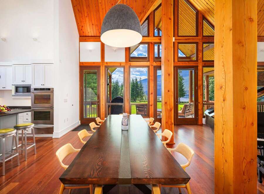 Experience breathtaking natural beauty from this stunning dining room, featuring a grand wooden table perfect for gatherings.