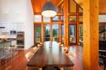 Experience breathtaking natural beauty from this stunning dining room, featuring a grand wooden table perfect for gatherings.