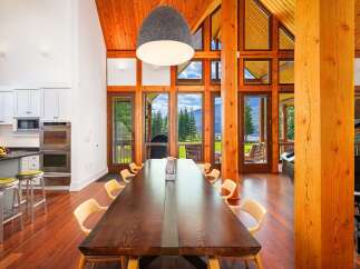 Experience breathtaking natural beauty from this stunning dining room, featuring a grand wooden table perfect for gatherings.
