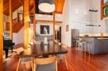 Experience luxurious living in this stunning open-concept home featuring a grand dining area with a large wooden table, perfect for entertaining.