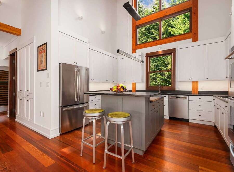 Experience luxury living in this stunning modern kitchen, featuring sleek white cabinetry and a spacious island perfect for entertaining.