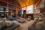 Experience ultimate luxury in this stunning mountain lodge living room, featuring a grand stone fireplace and soaring wooden ceilings.