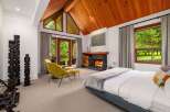 Experience luxury living in this stunning bedroom featuring a cozy fireplace and a comfortable seating area.