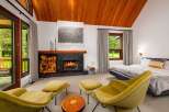 Experience ultimate relaxation in this cozy bedroom featuring a crackling fireplace and comfortable seating area.