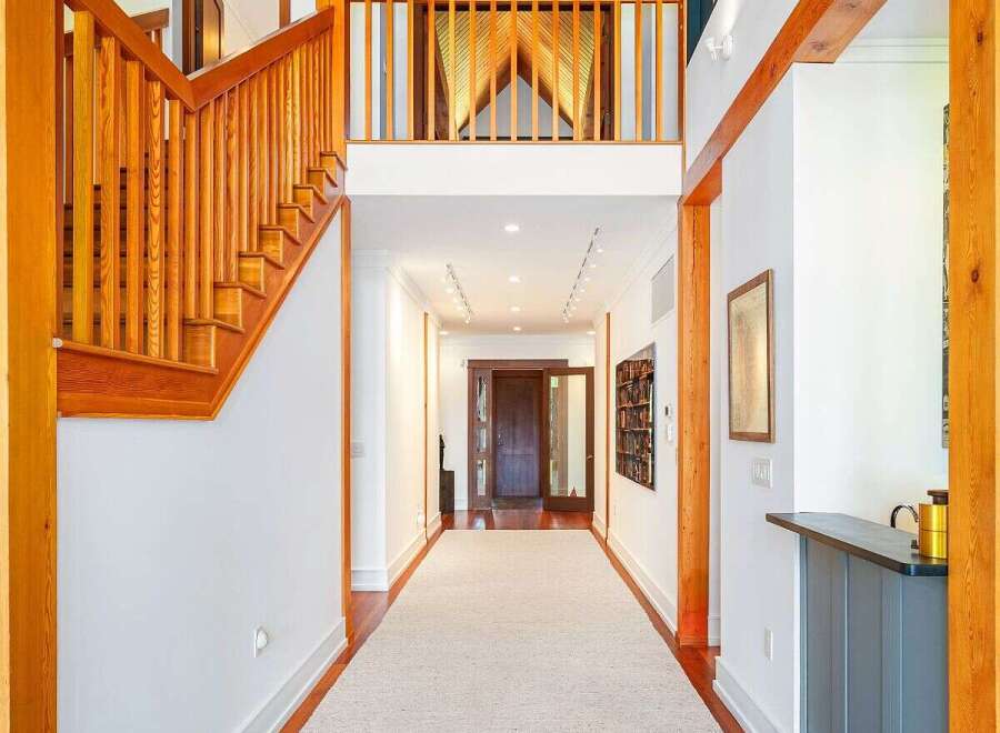 Experience grand living in this stunning entryway featuring soaring vaulted ceilings with rich wood paneling and exposed beams.