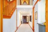 Experience grand living in this stunning entryway featuring soaring vaulted ceilings with rich wood paneling and exposed beams.