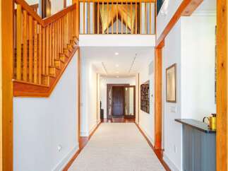 Experience grand living in this stunning entryway featuring soaring vaulted ceilings with rich wood paneling and exposed beams.