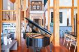 Experience luxury living in this grand home, featuring a stunning black grand piano as the centerpiece of a spacious, open-concept living area.