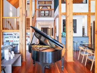 Experience luxury living in this grand home, featuring a stunning black grand piano as the centerpiece of a spacious, open-concept living area.