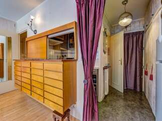 Discover this charming space featuring a unique wooden cabinet with ample drawer storage, perfect for organizing your belongings.
