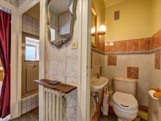 Discover this charming bathroom featuring a compact sink and a toilet, perfect for smaller spaces.