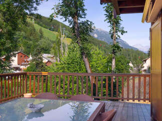 Enjoy breathtaking mountain views from this charming balcony, complete with a glass-top dining table and comfortable seating.