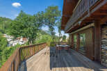 Experience breathtaking mountain views from this stunning wooden deck, perfect for outdoor dining and relaxation.