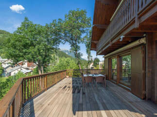 Experience breathtaking mountain views from this stunning wooden deck, perfect for outdoor dining and relaxation.