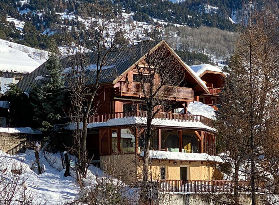Experience the charm of this stunning wooden chalet nestled in a snowy mountain landscape.
