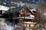 Experience the charm of this stunning wooden chalet nestled in a snowy mountain landscape.