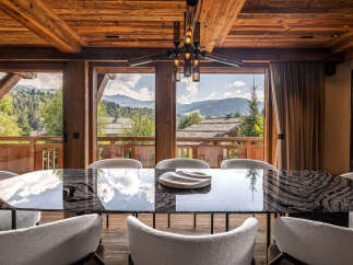 Experience luxurious mountain living in this stunning dining room, featuring a unique stone-inlaid table and plush seating.