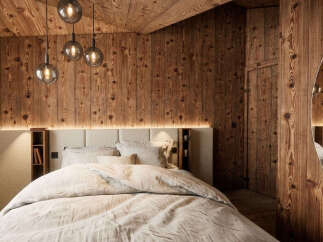Experience rustic luxury in this charming bedroom, featuring warm, natural wood paneling on the walls and ceiling.