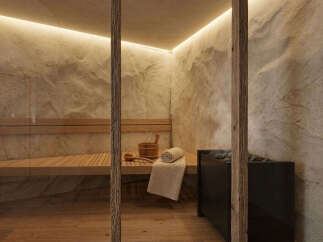 Experience ultimate relaxation in this luxurious sauna, featuring natural stone walls and warm wooden benches.