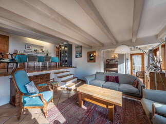 Experience the charm of this multi-level living space, featuring a cozy living area with a rustic wooden coffee table and plush seating, perfect for relaxation.