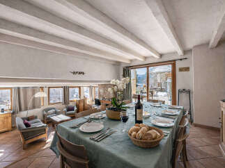 Experience elegant dining in this charming space, featuring a beautifully set table with a bottle of wine and fresh bread, perfect for intimate gatherings.
