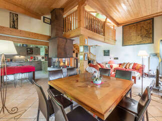 Experience rustic charm in this spacious open-plan living area, featuring a grand stone fireplace as the centerpiece.