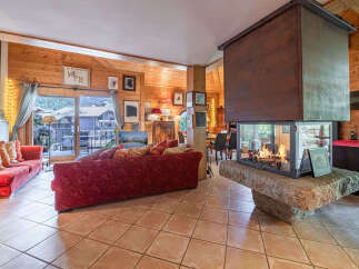 Experience cozy living in this charming mountain retreat, featuring a stunning glass-enclosed fireplace as the centerpiece of the spacious living area.